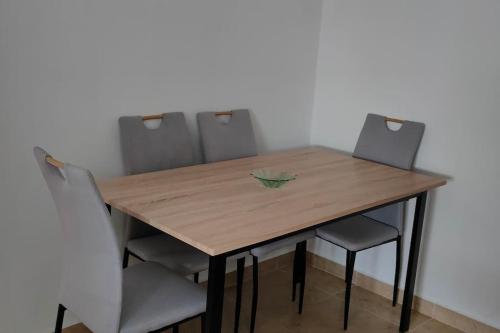 une table en bois entourée de quatre chaises dans l'établissement joli appartement de vacances, à Tetouan