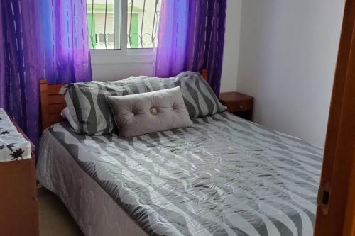 - un lit avec des rideaux violets dans une chambre dans l'établissement joli appartement de vacances, à Tetouan