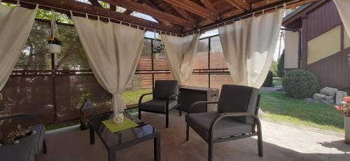 een afgeschermde veranda met stoelen en een tafel bij Dziewięciu z nieba 9 in Kaliska