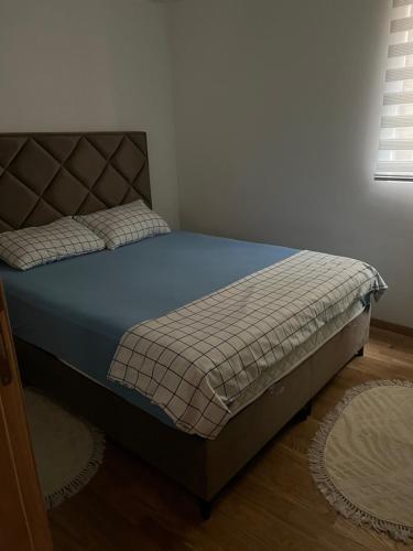 a bedroom with a bed with a blue bedspread at Apartman Jakov in Bečići