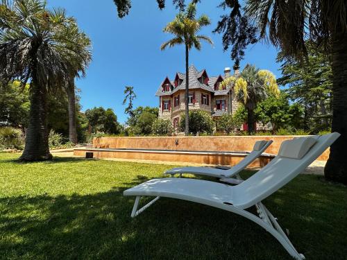 a white chair sitting in the grass in front of a house at Chalet Ficalho in Cascais