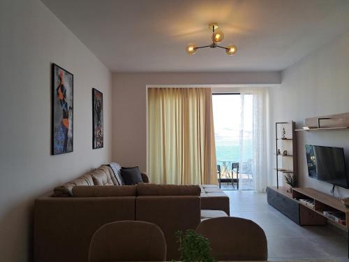 a living room with a couch and a television at Mamani Apartments Saranda in Sarandë