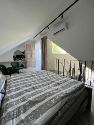 a bedroom with a large bed and a balcony at Beige Villa Balatonkenese in Balatonkenese