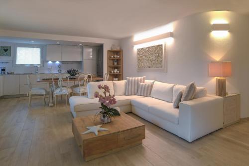 un soggiorno con divano bianco e tavolo di Villa Summer Luxury Apartment a Olbia