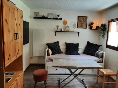 uma sala de estar com um sofá e uma mesa em Studio FLOCON 18m2 en RDC em Les Carroz d'Arâches