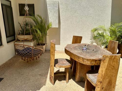 a wooden table and chairs in a room with plants at Kinneret View in Kinneret