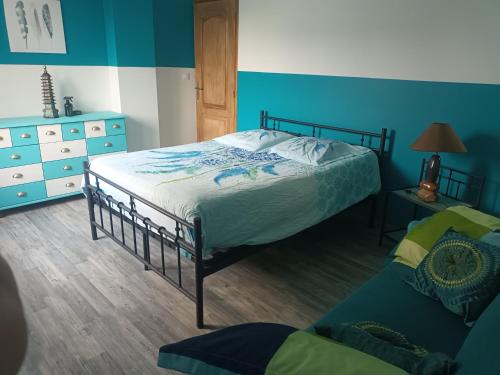 a bedroom with a bed and a dresser and a couch at Au chant des mandarins 2 gites de 15 personnes et un 3ème gite à proximité de 12 in Charmes