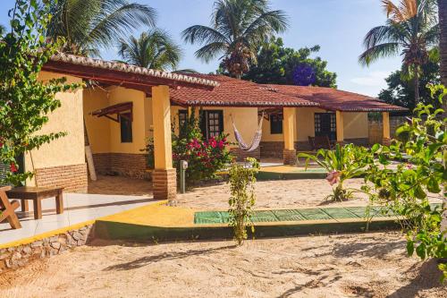 a house with a table and a bench in front of it at Pousada Sitio Phoenix in Prea