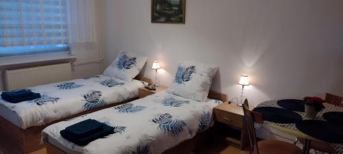a room with two beds with blue and white sheets at Apartament w centrum Iławy in Iława