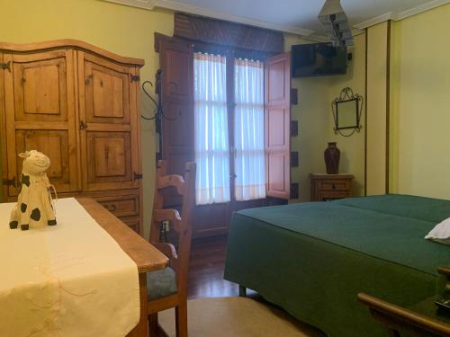 a bedroom with a bed and a table and a window at La Llosa de Sámano in Castro-Urdiales