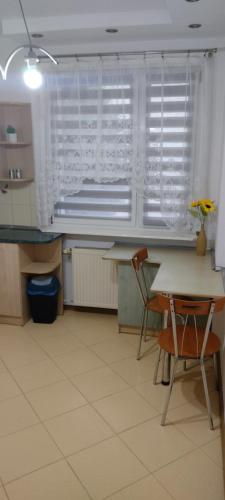a kitchen with a table and chairs and a window at Apartament w centrum Iławy in Iława