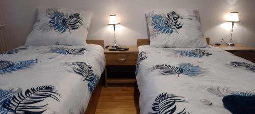 a bedroom with two beds with blue and white pillows at Apartament w centrum Iławy in Iława