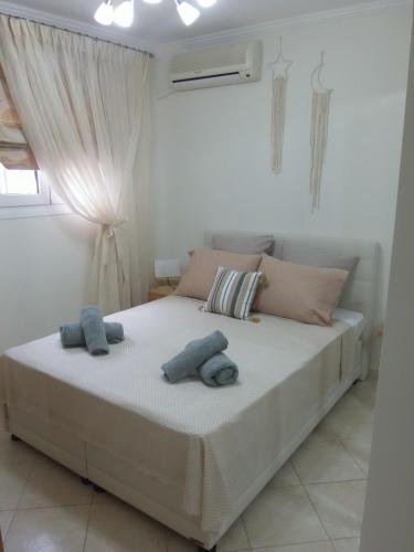 ein Schlafzimmer mit einem Bett mit zwei Handtüchern darauf in der Unterkunft by The Sea Apartment in Nea Iraklitsa