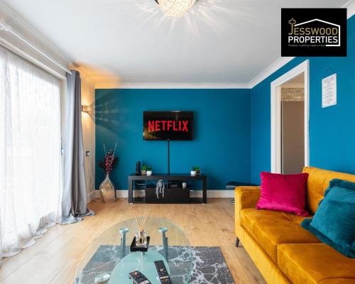 uma sala de estar com um sofá amarelo e uma televisão em Stylish 3 Bedroom Contractor House Stevenage by Jesswood Properties Short Lets Free Parking & Wifi em Stevenage