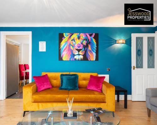 a living room with a yellow couch and a painting of a lion at Stylish 3 Bedroom Contractor House Stevenage by Jesswood Properties Short Lets Free Parking & Wifi in Stevenage