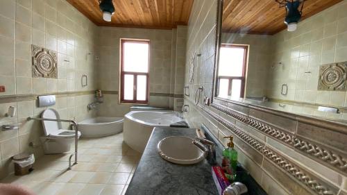 een badkamer met 2 wastafels, een bad en een toilet bij Stone Room in Alanya