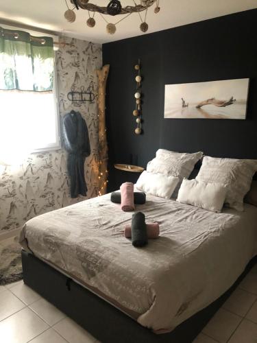 um quarto com uma cama grande com dois bichos de peluche em La guinguette du ti bonheur em Toulouse