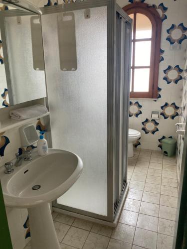 bagno con lavandino, doccia e servizi igienici di DesyMar Inn a Fontane Bianche