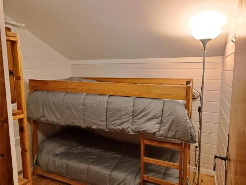 a bedroom with a bunk bed and a lamp at chalet près des pistes avec vue panoramique in Les Angles
