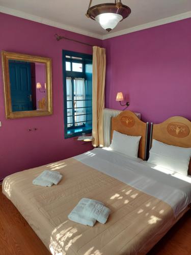 a bedroom with a large bed with purple walls at House Mitsiou Traditional Inn in Arnaia