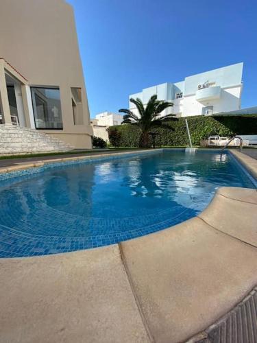 een groot zwembad voor een huis bij La Villa 91 in Monastir
