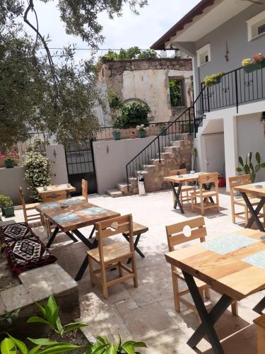 a group of wooden tables and chairs in a courtyard at OTELIA PANSIYON in Ayvalık