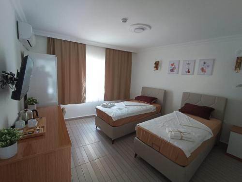 a hotel room with two beds and a couch at OTELIA PANSIYON in Ayvalık