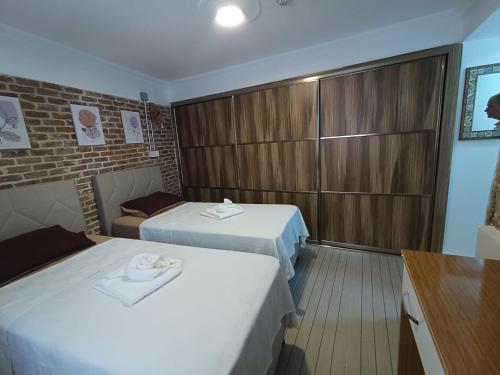 a hotel room with two beds and a closet at OTELIA PANSIYON in Ayvalık