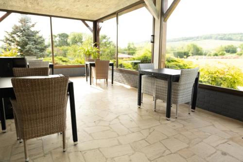 a patio with tables and chairs and windows at Chambre d'Hôte Les Ondines in Vinay
