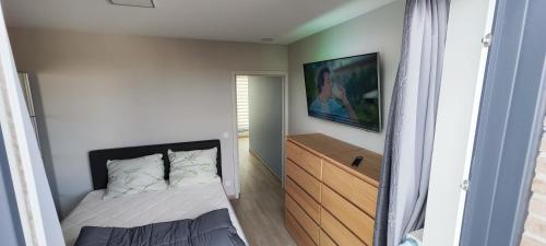 a small bedroom with a bed and a dresser at Koksijde Penthouse in Koksijde