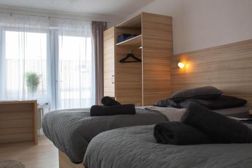 a bedroom with two beds and a large window at Modernes Studio mit großem Balkon, vollausgestatteter Küche und idealem Arbeitsplatz für Home Office in Gärtringen