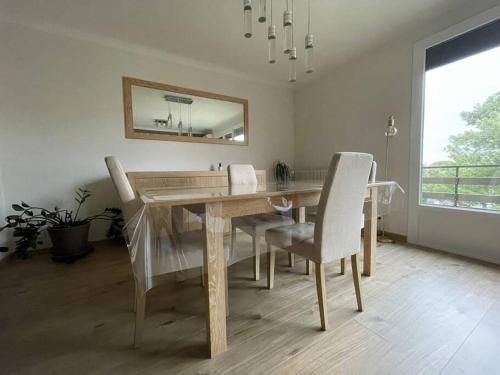 une salle à manger avec une table, des chaises et un miroir dans l'établissement Appartement 2 chambres +parking, à Narbonne