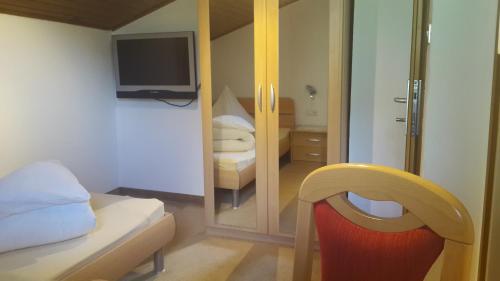 a small bedroom with a bed and a mirror at Oberangerhof in Lagundo