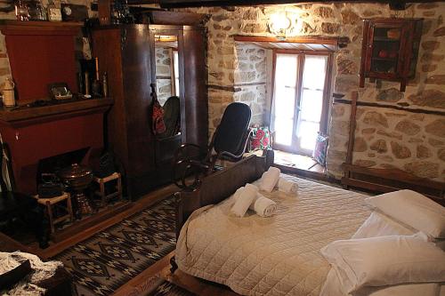 ein Schlafzimmer mit einem großen Bett in einem Steinzimmer in der Unterkunft ΤΑ ΚΩΝΣΤΑΝΤΑΔΙΚΑ in Arnea