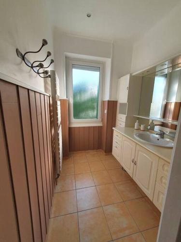 une salle de bain avec un lavabo et une fenêtre dans l'établissement Maison à 400 m du vieux port, à La Rochelle