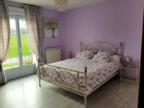 a bedroom with a bed with purple walls and a window at Chambre d'Hôte Les Ondines in Vinay