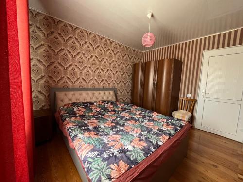 a bedroom with a bed with a floral bedspread at Жемчужина in Chok-Tal