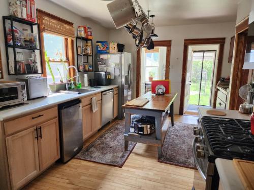 a kitchen with stainless steel appliances and a wooden floor at The Landerholm Bed and Breakfast in Wisconsin Rapids