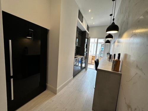 un couloir avec une porte noire et une cuisine dans l'établissement Appartement pret de la Mer, à Nice