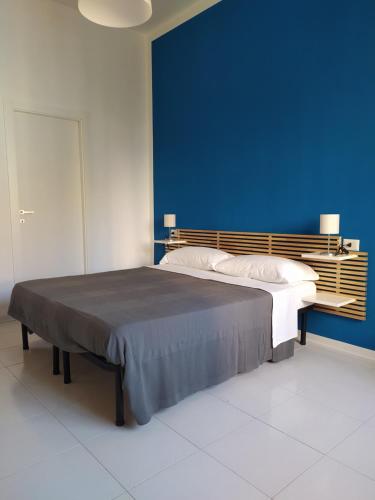 a bedroom with a large bed with a blue wall at NICE STAY in Naples