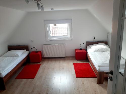 a room with two beds and two red rugs at Altstadthaus Günzburg in Günzburg