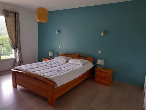 une chambre avec un lit et un mur bleu dans l'établissement Grande villa avec magnifique vue sur les montagnes, à Bidarray