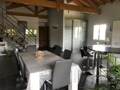 une salle à manger avec une table et des chaises et des escaliers dans l'établissement Grande villa avec magnifique vue sur les montagnes, à Bidarray