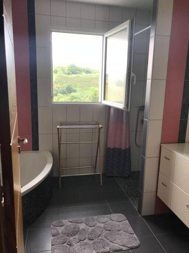 une salle de bain avec une baignoire et une fenêtre dans l'établissement Grande villa avec magnifique vue sur les montagnes, à Bidarray