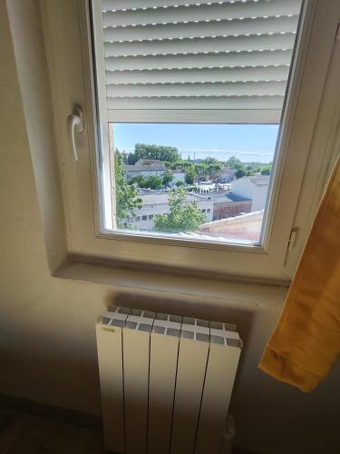 a window with a view of a building at Appartement de Charme L'Isle-sur-la-Sorgue sur la Sorgues in LʼIsle-sur-la-Sorgue