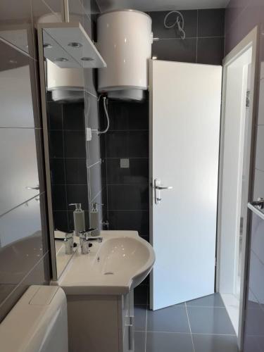 a bathroom with a sink and a mirror at Apartman Čarija 2 in Trogir