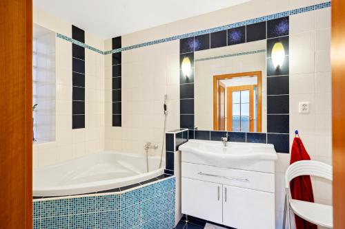 a bathroom with a tub and a white sink at Large private apartment with garden view, terrace and free parking in Bratislava