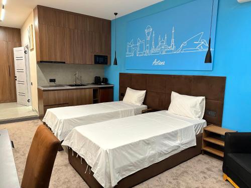 a bedroom with two beds and a blue wall at Prego apartments Astana in Astana