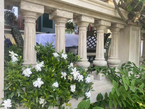 Ein Haufen weißer Blumen auf einer Veranda in der Unterkunft il Motto di Tommy in Castelveccana