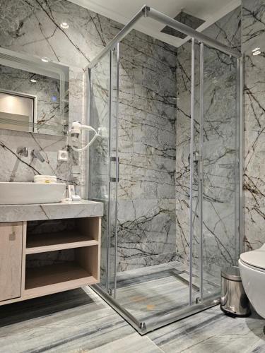 a bathroom with a shower and a sink at Sea Coast Resort Halkidiki in Yerakiní